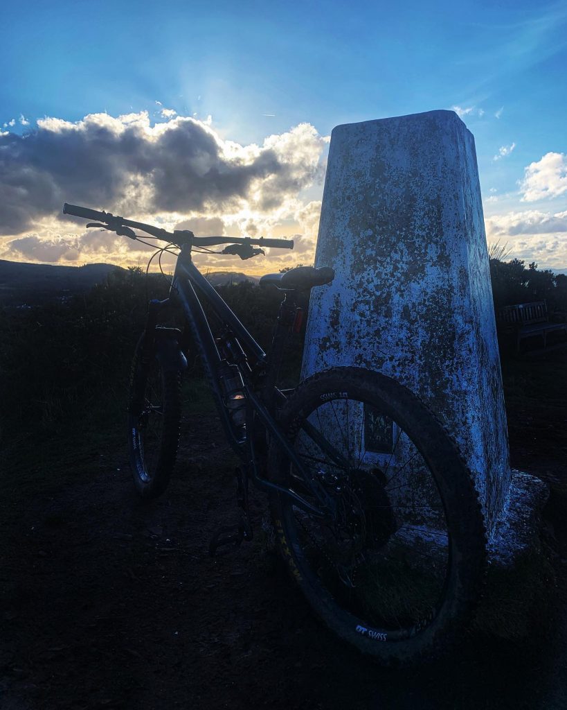 Sunset at Braid Hills trig point with mountain bike